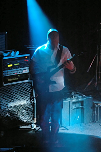 Shot of the guitar player for Counterfist backlit by a blue beam of light.  John Schlick was the Lighting Designer for this show.