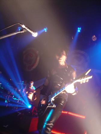 Photo of Biz of the Genitorturers in blue beams that John Schlick was the Lighting Designer for.