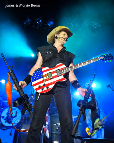 Photo of Ted Nugent holding guns that John Schlick was the Concert Lighting Designer for.